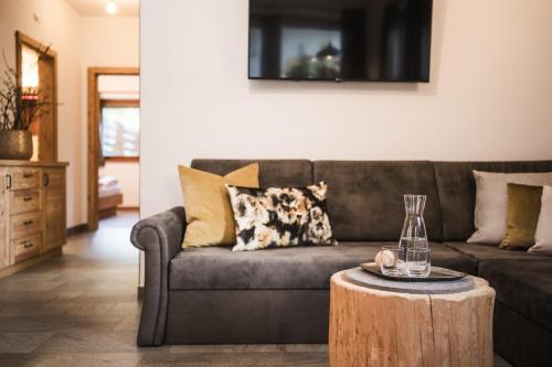 a living room with a couch and a table at Enzianhof - Nature Apartments in San Giovanni in Val Aurina