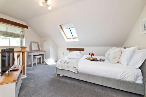 a bedroom with a large white bed and a desk at Woodland Cottage in Llanasa