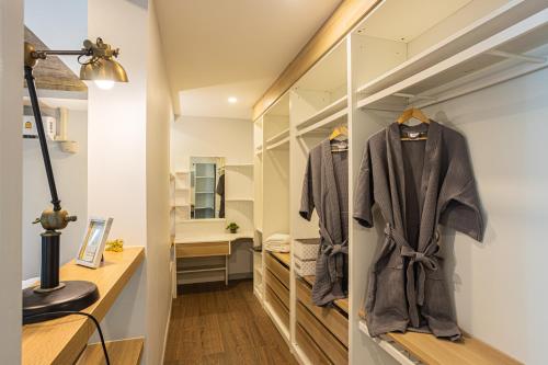 4BDR luxury pool villa & office space in Cherngtalay-Bangtao في Ban Phru Champa: غرفة ملابس مع مرآة وروب
