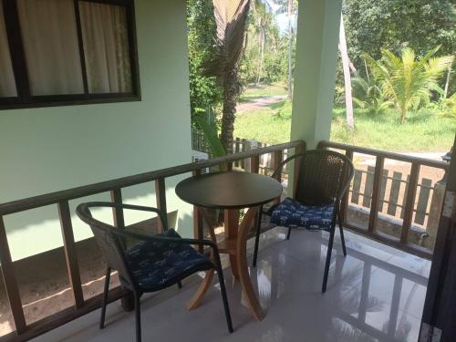 a table and chairs on a balcony with a view at Wasin House One Bedroom - Maenum in Mae Nam