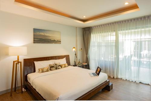 - une chambre avec un lit et une grande fenêtre dans l'établissement 4BDR luxury pool villa & office space in Cherngtalay-Bangtao, à Ban Phru Champa