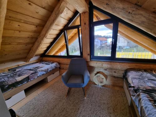 een slaapkamer met 2 bedden en een stoel in een hut bij Vila Vrhi in Pregrada