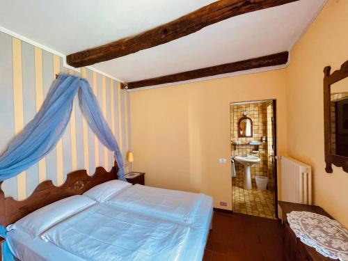Schlafzimmer mit einem Bett mit blauem Baldachin in der Unterkunft Rustico Nicand in Cannobio