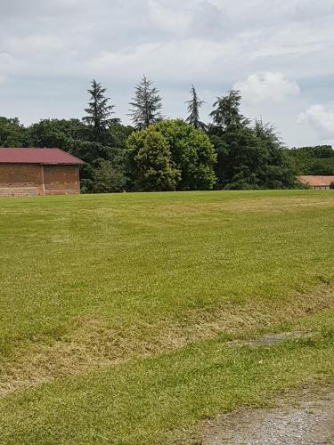 a large field of grass with a building and trees at Appartement T2 face au golf in Buzet-sur-Tarn