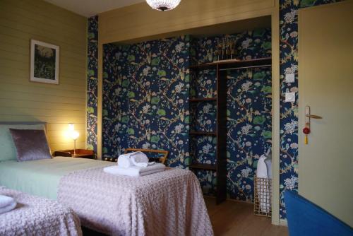 a bedroom with a bed and two tables in it at Chambres d'Hôtes La mésange à tête Bleue in Pierre-de-Bresse