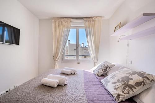 une chambre avec un grand lit avec deux serviettes dessus dans l'établissement L'EDEN SQUARE Apartment for 4 By Sunset, à Antibes