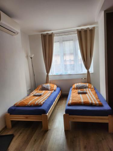 two beds sitting in a room with a window at Ubytováni u PÁji in Kynšperk nad Ohří