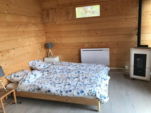 une chambre avec un lit dans une cabane en bois dans l'établissement Perchoir de ceuse, à Sigoyer
