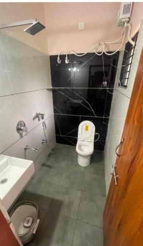 a bathroom with a toilet and a sink at The room for two in Madikeri