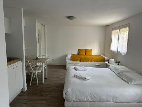 ein Schlafzimmer mit einem Bett und einem Tisch sowie eine Küche in der Unterkunft Tours, Touraine et Chateaux de la Loire in Fondettes