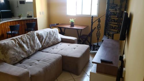 sala de estar con sofá y mesa en Apartamento 2 Quartos Praia do Morro, en Guarapari