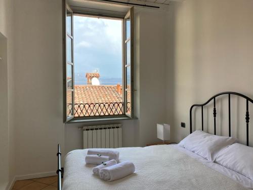 ein Schlafzimmer mit einem Bett und einem Fenster mit Handtüchern darauf in der Unterkunft Domus Dea 4 Città Alta in Bergamo