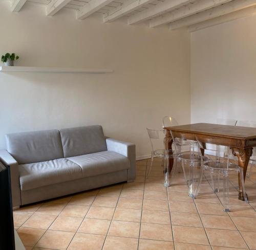 ein Wohnzimmer mit einem Sofa und einem Tisch in der Unterkunft Domus Dea 4 Città Alta in Bergamo