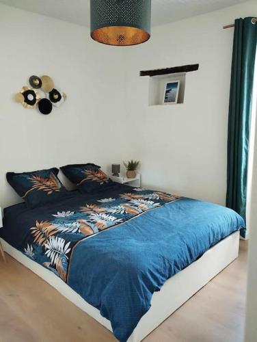 - un lit avec une couette bleue dans une chambre dans l'établissement Maison Corse avec piscine et sauna - La Casa Lilia, à Campile