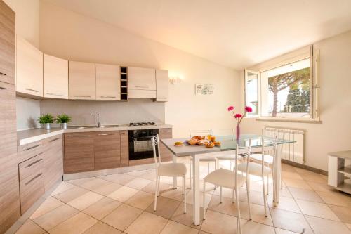 リオトルトにあるCasa Vacanze Vignarca - Località Perelliの白いキャビネット、テーブルと椅子付きのキッチンが備わります。