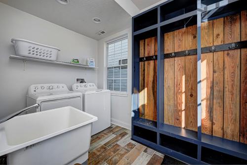 a kitchen with wooden cabinets and a washer and dryer at Spacious Bates-Hendricks Home ~ 5 Min to Lucas Oil in Indianapolis