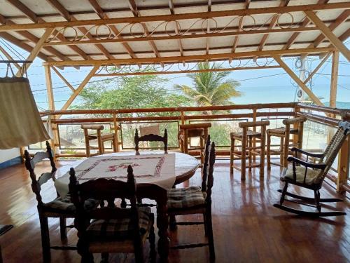 a dining room with a table and chairs on a porch at Los Pinos condominio piso 2 in Zorritos