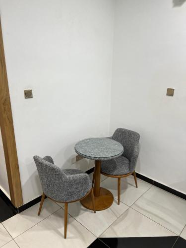 uma mesa e duas cadeiras num quarto em Empress Guest House em North Legon
