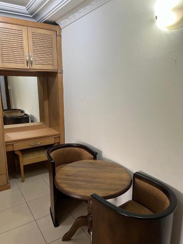 a wooden table and chairs in a room at Empress Guest House in North Legon