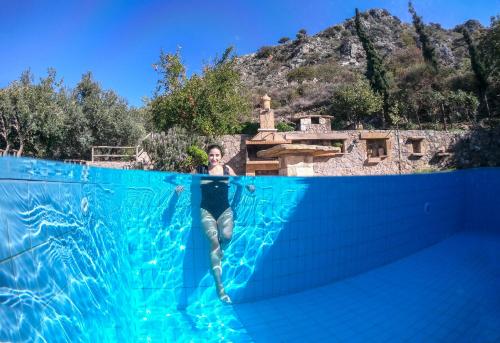 a woman is standing in a swimming pool at Malathiros Traditional Villas in Maláthiros