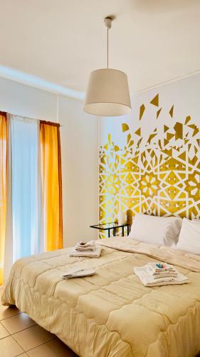 um quarto com uma cama grande e uma parede amarela e branca em Casa Lilla em Monreale