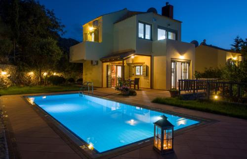 a swimming pool in front of a house at night at Malathiros Traditional Villas in Maláthiros