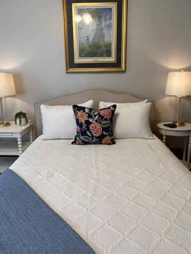 uma cama com duas almofadas e uma fotografia na parede em Spacious Suite Wkitchenette em Ligonier
