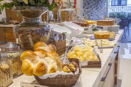 a buffet with baskets of bread and other pastries at São Carlos Marklin Suítes in São Carlos