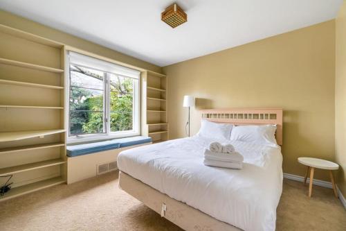 una camera con un letto bianco e una finestra di Tranquil Haven near Attractions: 4 BD Suite a Vancouver