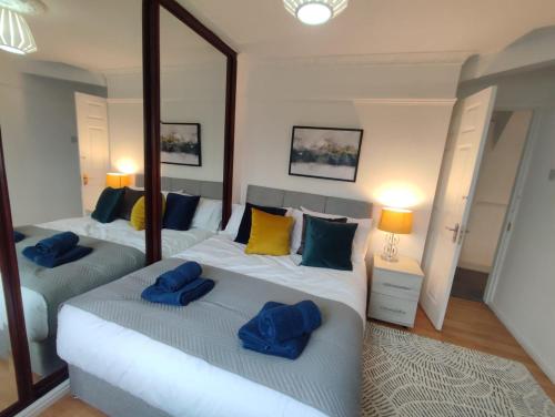 een slaapkamer met twee bedden met blauwe kussens erop bij Sigma Palace Free Parking in Longbenton