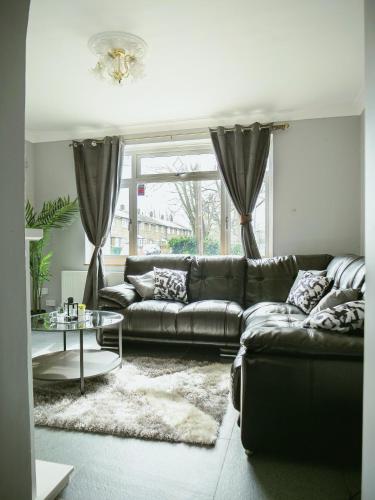 a living room with a couch and a table at Urban Oasis in Abbey Wood