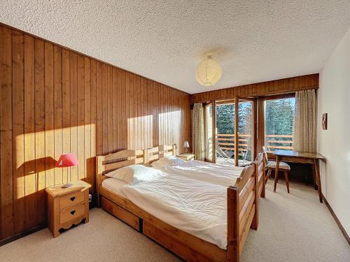 a bedroom with a large bed and a desk at Richemont 213 in Verbier