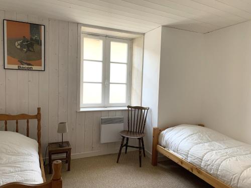 ein Schlafzimmer mit einem Bett und einem Stuhl und einem Fenster in der Unterkunft Maison de vacances BERENICE à St Martin de Ré in Saint-Martin-de-Ré