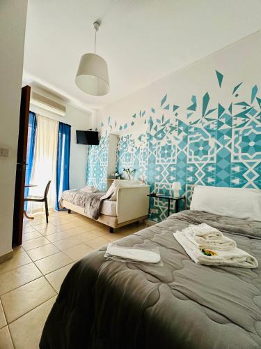 um quarto com uma cama com uma parede azul estampada em Casa Lilla em Monreale