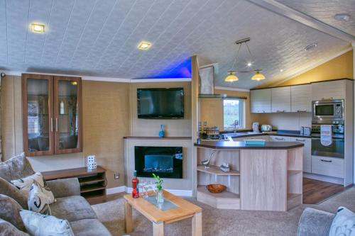 a living room with a couch and a kitchen at Newlands Holidays in Bridport