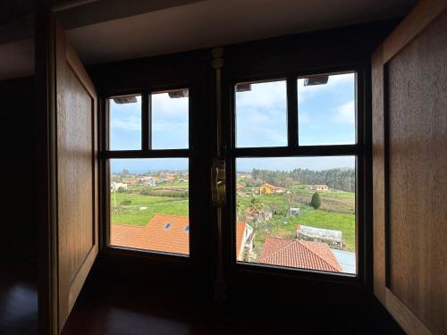 an open window with a view of a roof at Hotel El Rosal de Cudillero in Cudillero
