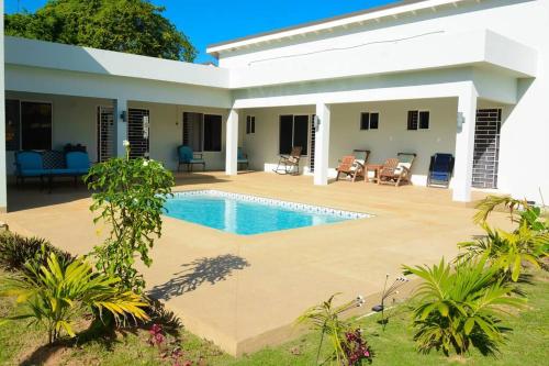 a house with a swimming pool in front of it at Retreat 2 Jamaica in Runaway Bay