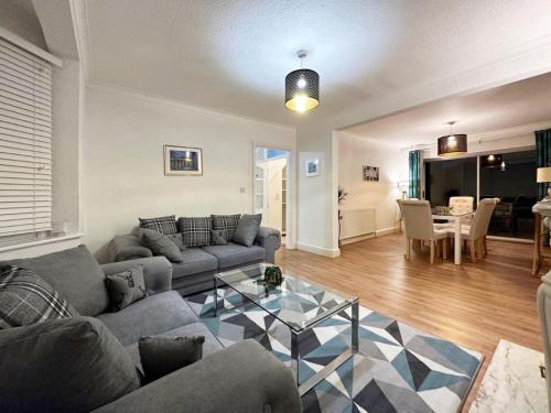 a living room with a couch and a table at Charming 3-bedroom family home in London