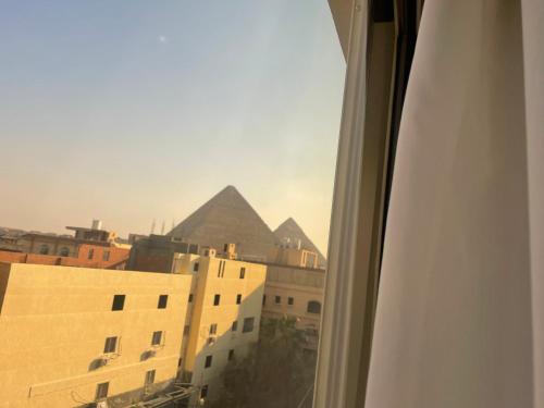 a view of the pyramids from a window of a building at Diyar Pyramids Inn in Cairo