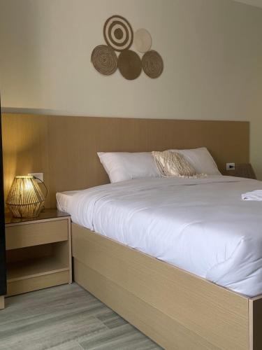 a bedroom with a large white bed and a night stand at Diyar Pyramids Inn in Cairo