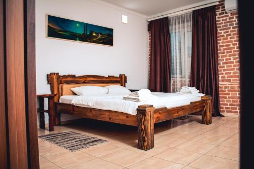 Schlafzimmer mit einem Holzbett mit weißer Bettwäsche in der Unterkunft Fortetsya in Uman