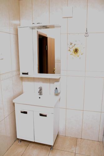 a white bathroom with a sink and a mirror at Fortetsya "Стабільне електропостачання!" in Umanʼ