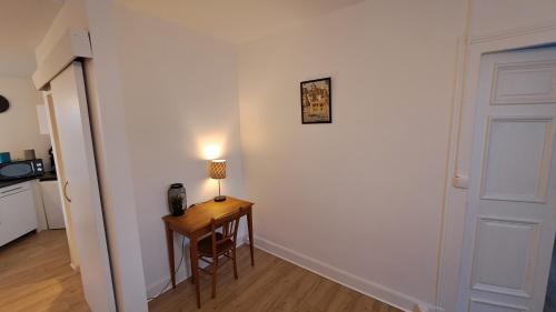 a room with a table with a lamp and a door at Appartement confort deux Etoiles in Dole