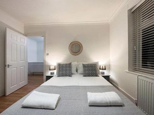 sypialnia z dużym białym łóżkiem z 2 poduszkami w obiekcie Charming 3-bedroom family home w Londynie
