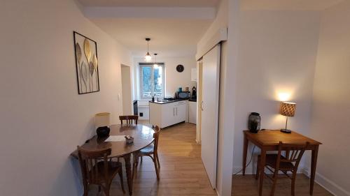 cocina y comedor con mesa y sillas en Appartement confort deux Etoiles en Dole
