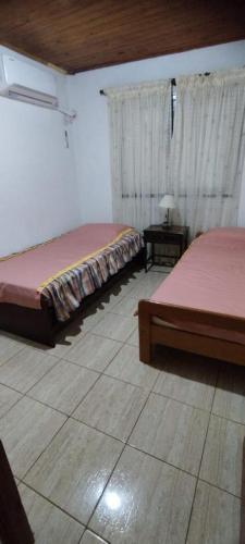 a bedroom with two beds and a table with a window at Departamentos Alicia in Puerto Rico