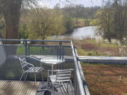 een tafel en stoelen op een terras met uitzicht op een rivier bij Wasserblick Stadtidyll 3 Zimmer Apartment Lübeck in Lübeck