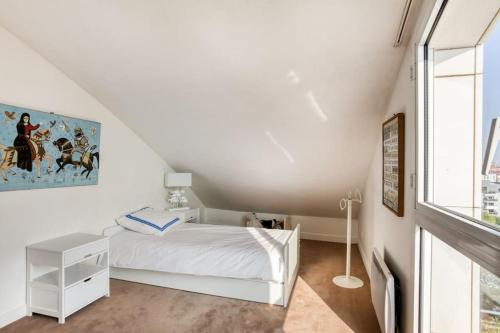 une chambre blanche avec un lit blanc et une fenêtre dans l'établissement Superb duplex with stunning view of Eiffel Tower, à Boulogne-Billancourt