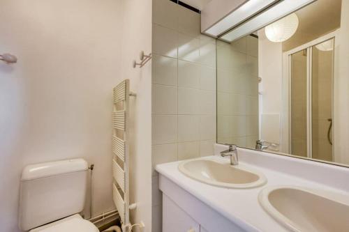 une salle de bain blanche avec des toilettes et un lavabo dans l'établissement Superb duplex with stunning view of Eiffel Tower, à Boulogne-Billancourt