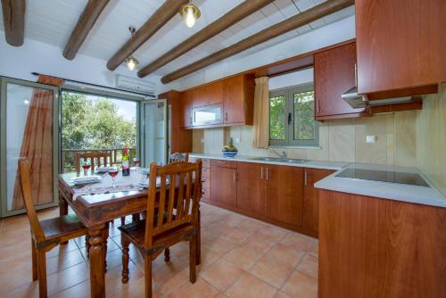 a kitchen with a wooden table and wooden cabinets at Malathiros Traditional Villas in Maláthiros